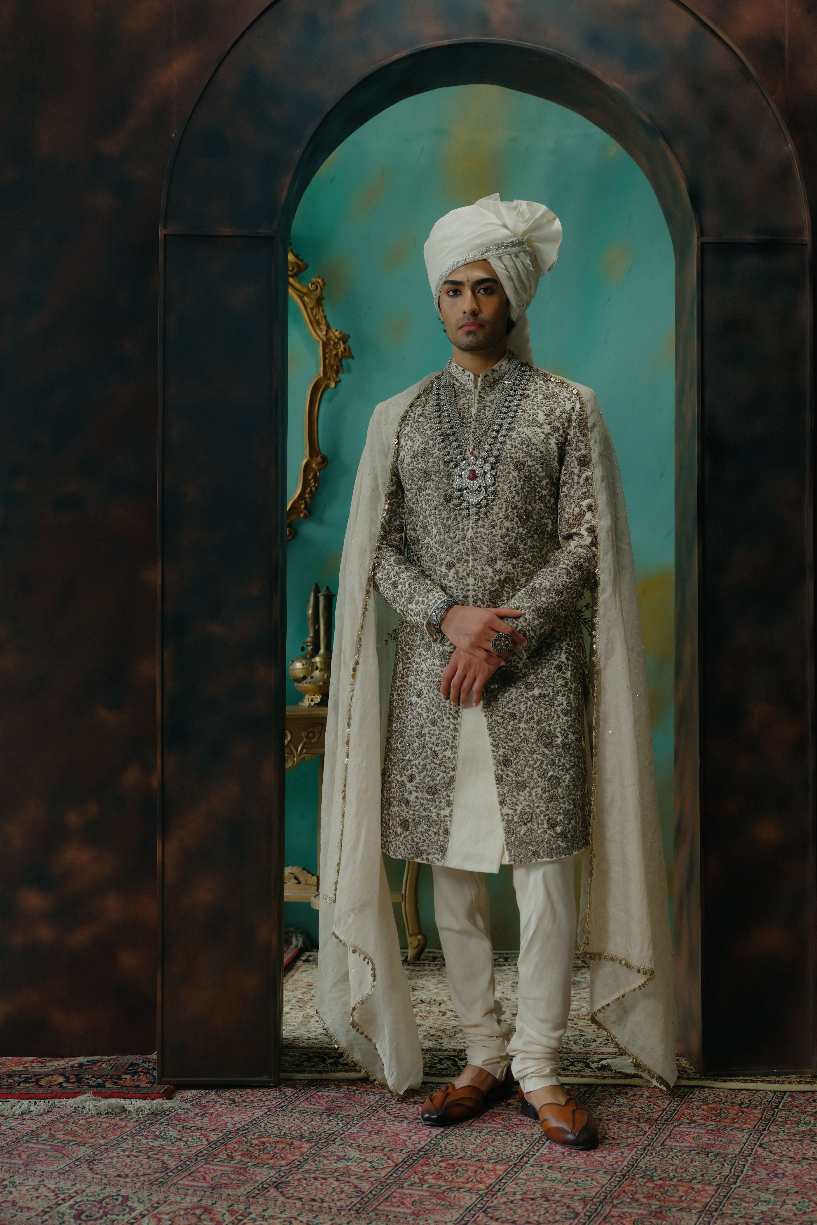 Ivory and silver embroidered sherwani in a royal teal archway